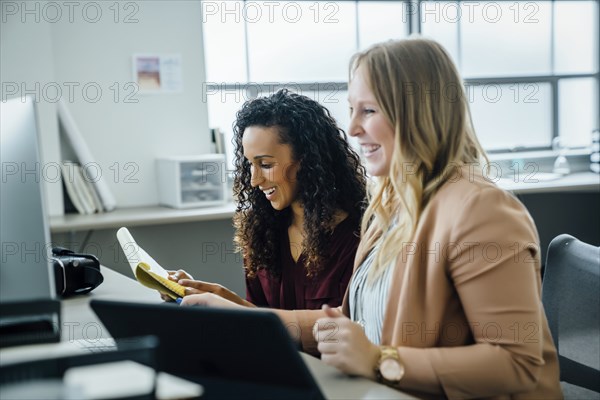 Smiling women by computer in office
