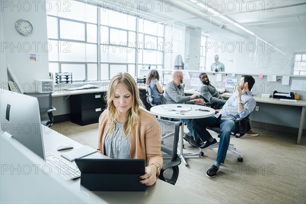 Woman using digital tablet in office