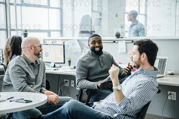 Men smiling during meeting in office