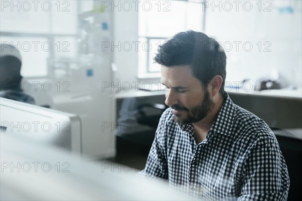Bearded man behind window in office