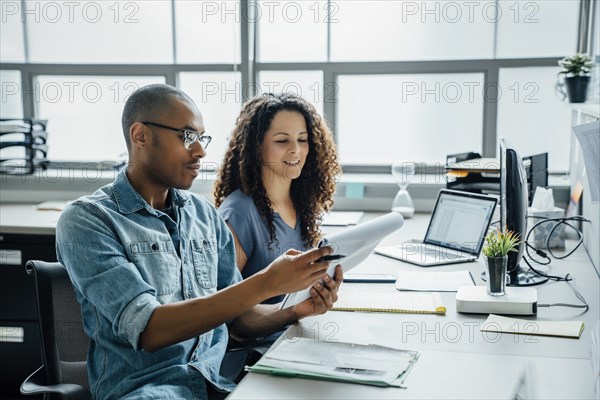 Coworkers with note pad in office