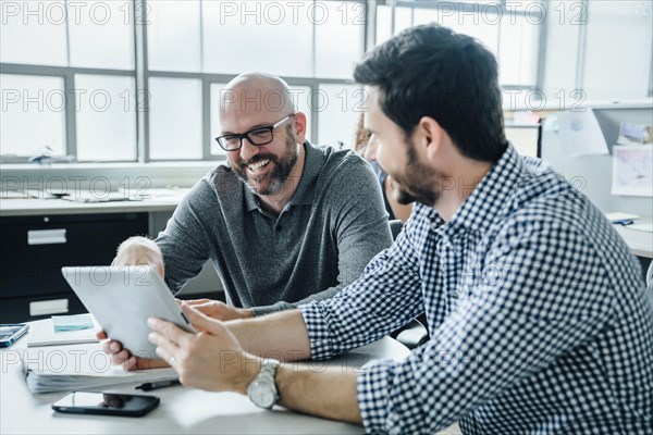 Men using digital tablet during meeting in office