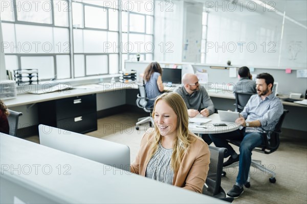 Smiling woman using computer in office