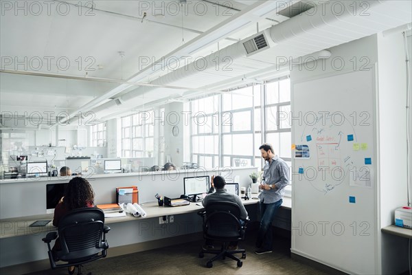 Workers using computers in office