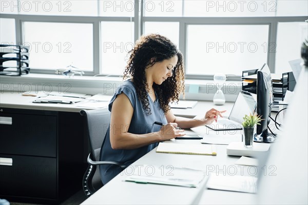 Woman using smart phone in office