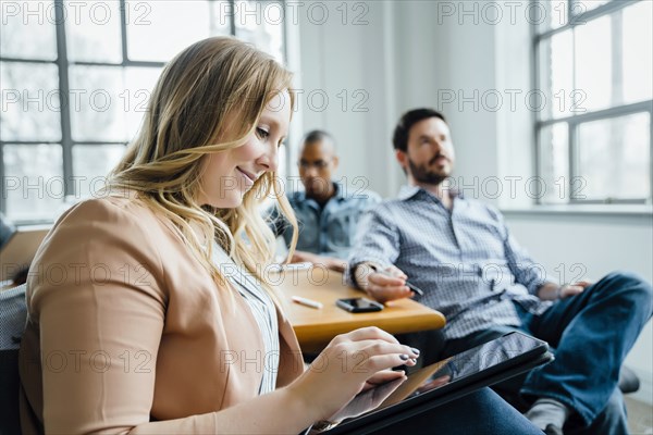 Woman using digital tablet during meeting