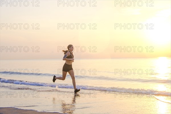 Woman jogging on beach at sunset