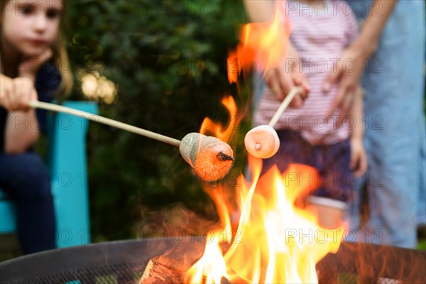 Family toasting marshmallows over brazier