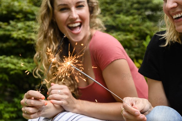 Smiling women holding sparkler