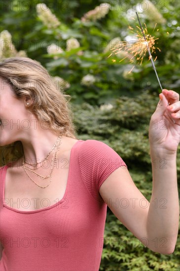 Young woman holding sparkler