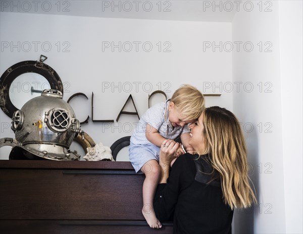 Mother holding son on top of drawers