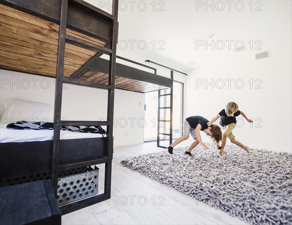 Boys play fighting by bunk beds