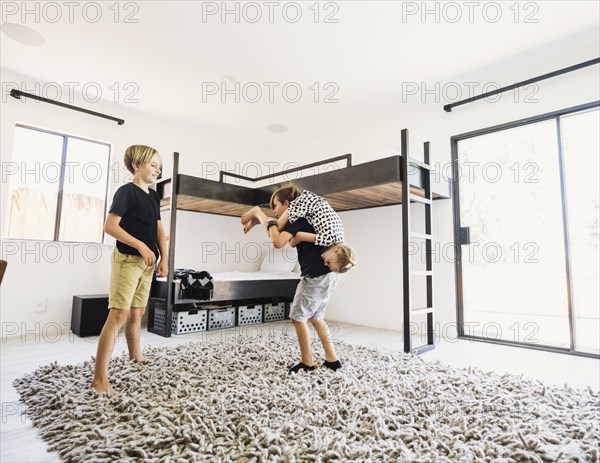 Siblings playing by bunk beds