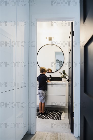 Boy washing his hands in bathroom