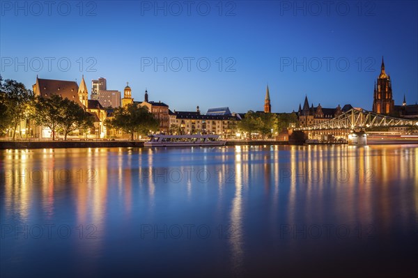 Buildings by river at sunset in Frankfurt