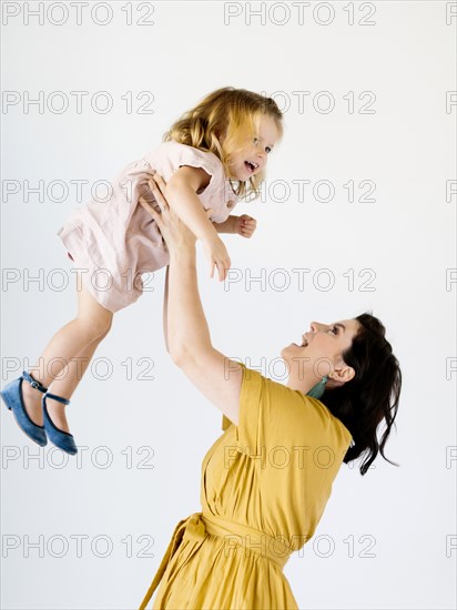 Mother holding her daughter aloft