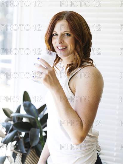 Mid adult woman holding glass of water