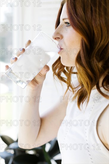 Mid adult woman drinking water