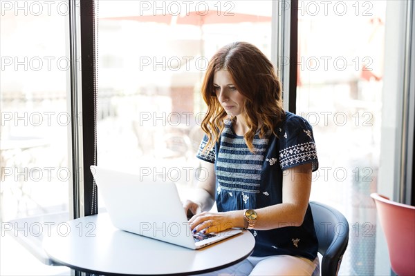 Woman using laptop in cafe