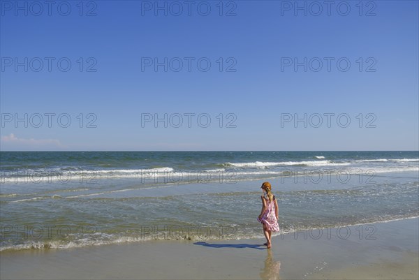 Rear view of girl walking on beach