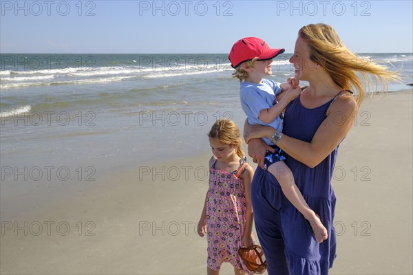 Mother and children walking on beach