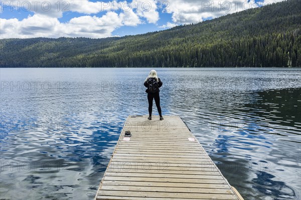 Woman standing on jetty on lake in Stanley