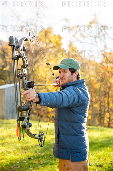 Young man aiming bow and arrow