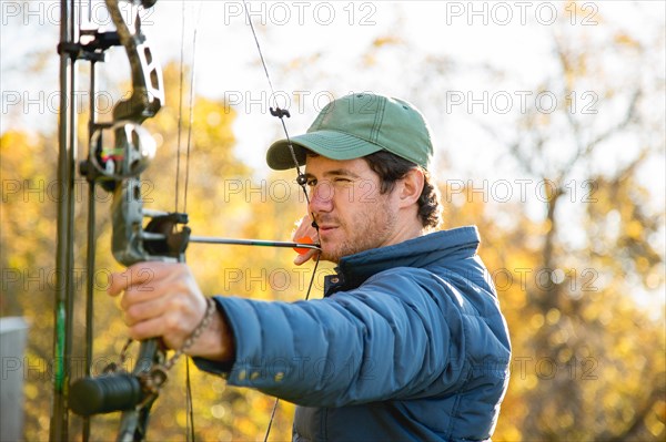 Young man aiming bow and arrow