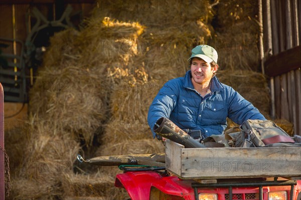 Young man driving 4x4 out of barn