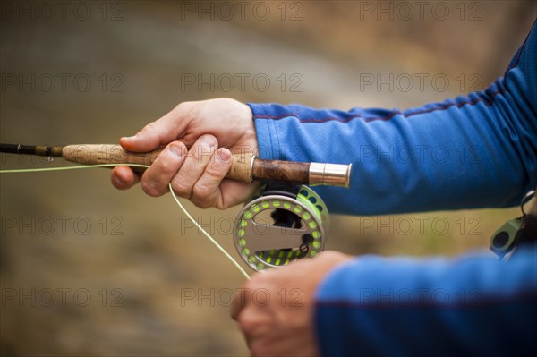 Man's hands holding fishing rod