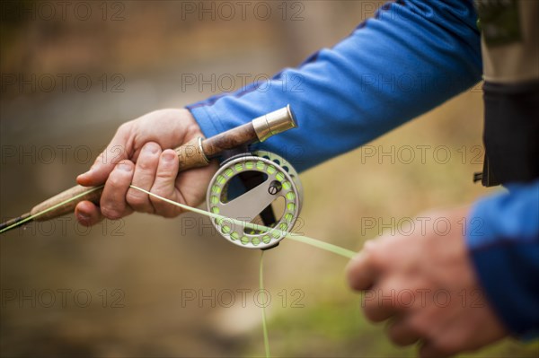 Man's hands holding fishing rod