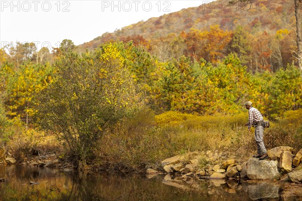 Man fly-fishing in river during autumn in Giles County