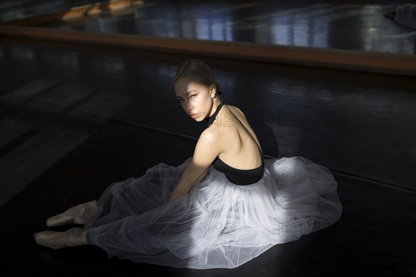 Ballet dancer sitting in shadow