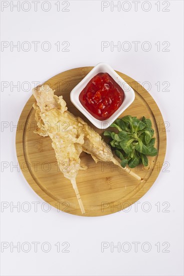 Deep fried sausages on skewers with tomato sauce