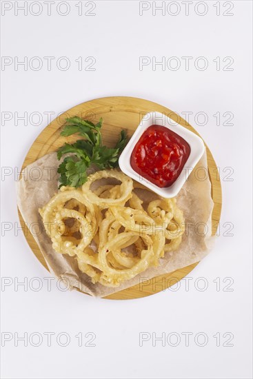 Onion rings with tomato sauce on cutting board