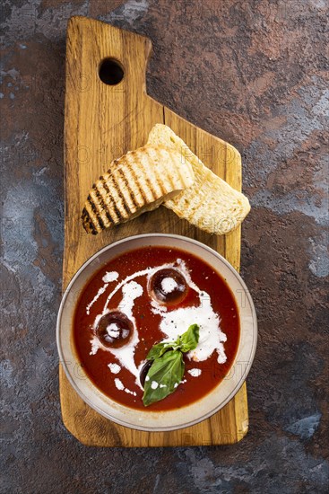 Tomato soup with toast on cutting board