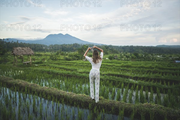 Rear view of woman standing in rice paddy in Bali