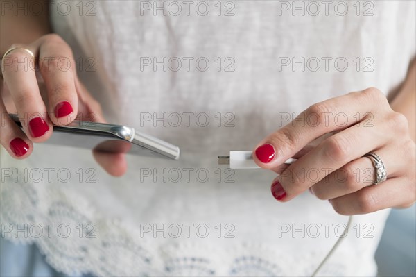 Woman plugging charger into smart phone