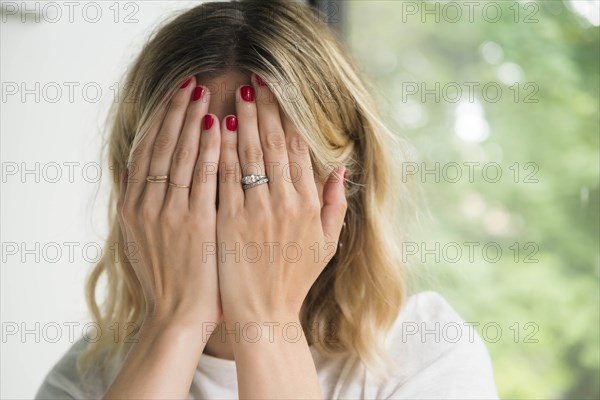 Woman with her hands covering her face