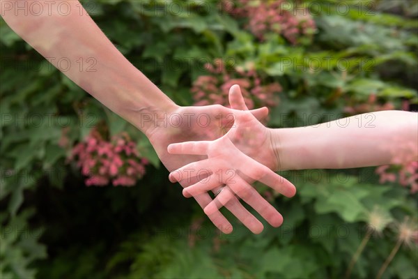 Double exposure of mother and daughter's hands