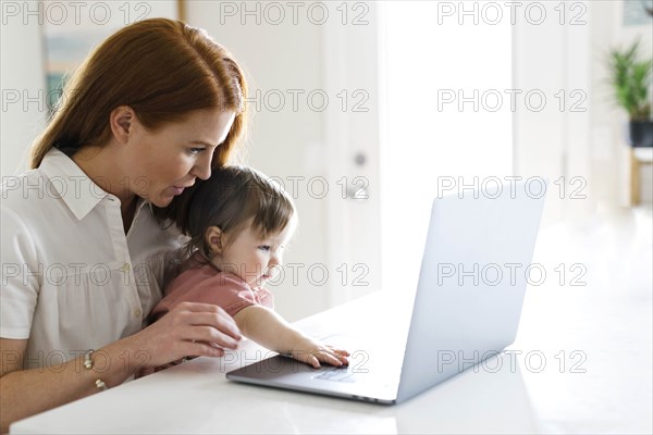 Mother and daughter using laptop