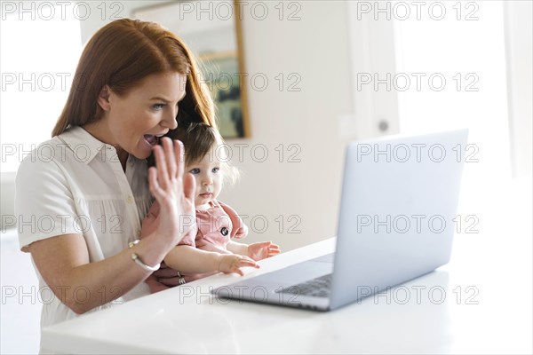 Mother and daughter using laptop to video chat