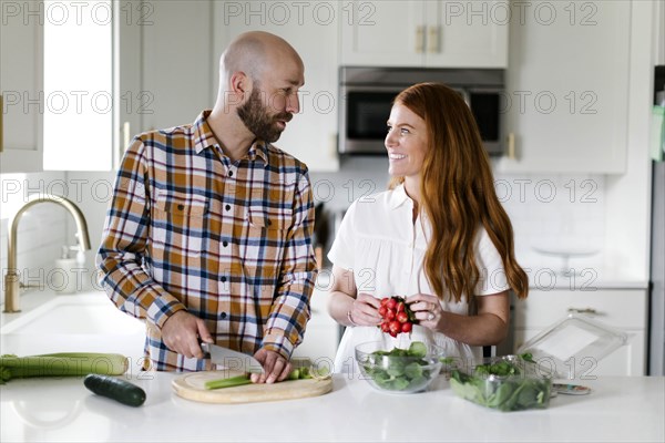 Couple chopping vegetables in kitchen