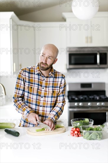 Man chopping vegetables in kitchen