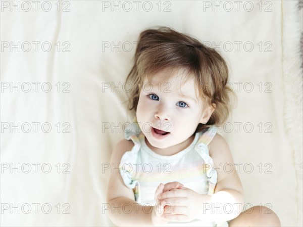 Baby girl lying on bed