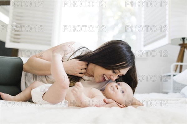 Smiling mother lying with her son on bed