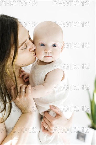 Mother kissing her baby boy's cheek