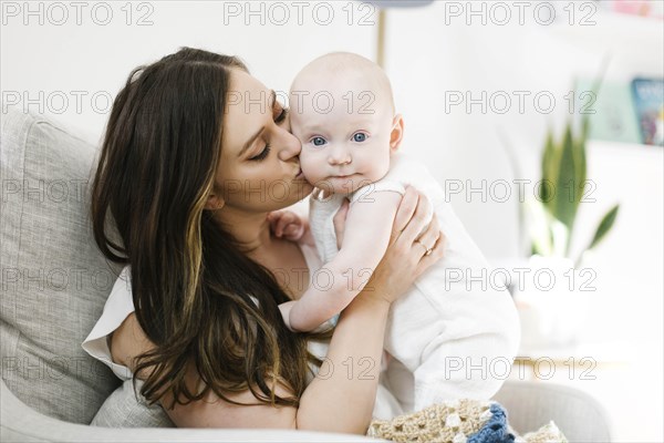 Mother kissing her baby boy's cheek