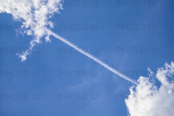 Vapor trail between clouds