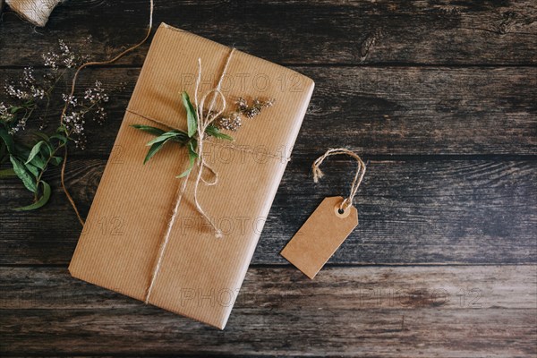 Present wrapped in brown paper and string with label and flowers